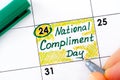 Woman fingers with pen writing reminder National Compliment Day in calendar Royalty Free Stock Photo