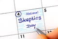 Woman fingers with pen writing reminder National Skeptics Day in calendar Royalty Free Stock Photo