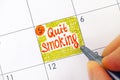 Woman fingers with pen writing reminder Quit Smoking in calendar Royalty Free Stock Photo