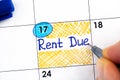 Woman fingers with pen writing reminder Rent Due in calendar Royalty Free Stock Photo