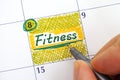 Woman fingers writing reminder Fitness in calendar Royalty Free Stock Photo