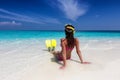 Woman with fins and mask for snorkeling sits on the beach Royalty Free Stock Photo