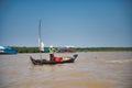 Woman in fishing boat floating on rippling muddy river water Royalty Free Stock Photo