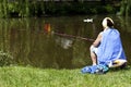 Woman fishing in a city park Royalty Free Stock Photo
