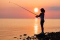 Woman fishing on Fishing rod spinning at sunset background Royalty Free Stock Photo