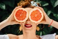 Woman fit girl holding two halfs of grapefruit Royalty Free Stock Photo