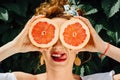 Woman fit girl holding two halfs of grapefruit Royalty Free Stock Photo