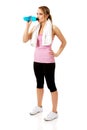 Woman in fitness clothes drinking isotonic drink.