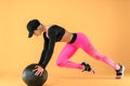 Woman in fitness clothes training with a medicine ball. Female athlete doing abdomen workout using a medicine ball