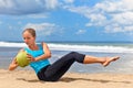 Woman fitness exercise with green coconuts on ocean beach Royalty Free Stock Photo