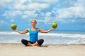 Woman fitness exercise with green coconuts on ocean beach Royalty Free Stock Photo