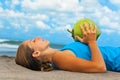 Woman fitness exercise with green coconuts on ocean beach Royalty Free Stock Photo