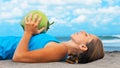 Woman fitness exercise with green coconuts on ocean beach Royalty Free Stock Photo