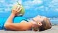 Woman fitness exercise with green coconuts on ocean beach Royalty Free Stock Photo