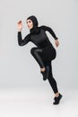 Woman fitness muslim posing running jumping isolated over white wall background Royalty Free Stock Photo