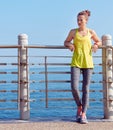 Woman in fitness outfit looking into distance at embankment Royalty Free Stock Photo