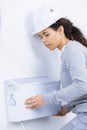 Woman fitting radiator to wall Royalty Free Stock Photo