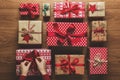 Woman fixing a bow on beautifuly wrapped vintage christmas presents on wooden background