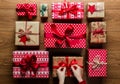 Woman fixing a bow on beautifuly wrapped vintage christmas presents on wooden background