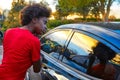 Woman fixing earings on car window at sunset Royalty Free Stock Photo