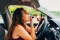 Woman fixing her lipstick in a car. Reckless drivier