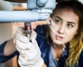 Woman fixing kitchen sink at home