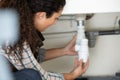 Woman fixing kitchen sink