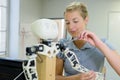 Woman fixing robotic arm