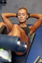 Woman flexing abdominal muscles on bench in gym Royalty Free Stock Photo