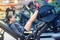 Woman flexing muscles on leg press machine in gym Royalty Free Stock Photo