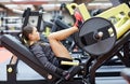 Woman flexing muscles on leg press machine in gym Royalty Free Stock Photo