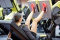 Woman flexing muscles on leg press machine in gym Royalty Free Stock Photo