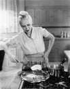 Woman flipping eggs on stove Royalty Free Stock Photo