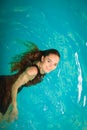 Woman floating relaxing in swimming pool water. Royalty Free Stock Photo