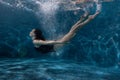 Woman floats under water in the pool. Royalty Free Stock Photo