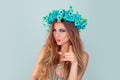 Woman with floral crown on head looking pointing at you