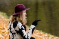 Woman in a floral patterned coat and wine red hat in the park, by the river. Happy girl, colorful autumn forest. Portrait of lady Royalty Free Stock Photo