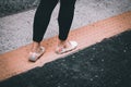 Woman in floral shoes walking on a yellow painted pavement