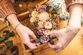 Woman florist collects a flower composition in a wooden box. Spring bouquet of roses in pastel colors in a flower shop Royalty Free Stock Photo