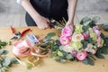 Woman florist creating beautiful bouquet in flower shop. Working in flower shop. Girl assistant or owner in floral