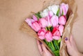 Woman florist makes a bouquet of pink tulips