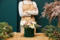 A woman florist ready bouquet in a beautiful green corduroy corduroy box, an empty place for text