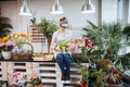 Woman florist sitting and arranging pink tulips in flower shop Royalty Free Stock Photo