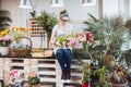 Woman florist sitting and arranging pink tulips in flower shop Royalty Free Stock Photo