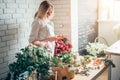 Woman florist taking pictures of flowers with mobile phone