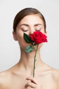 Woman with flower with closed eyes sniffing a rose charm