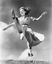 Woman in a flowing dress leaping through the air