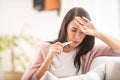 Woman with flu having fever measures temperature by holding thermometer in her mouth Royalty Free Stock Photo