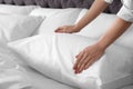 Woman fluffing soft pillow in bedroom Royalty Free Stock Photo