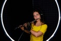 Woman flutist in headphones playing the large orchestral flute. Female flute player plays in recording studio, copy space. Record